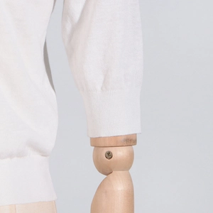 Close-up of the fine knit texture and ribbed cuff design on the white floral knit top