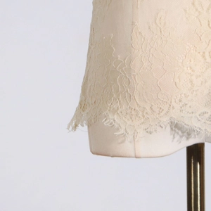 Detail of elegant beige eyelash lace fabric with intricate floral patterns for women's tops