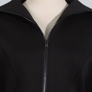 Detailed close-up of premium black jacket featuring a smooth dark metal zipper closure