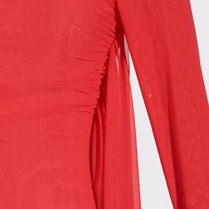 Detail of red mesh long-sleeve top featuring side ruching and delicate fabric texture