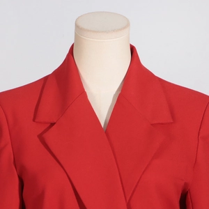 Détails des épaules structurées et du revers d'un blazer rouge à coupe cintrée et longue