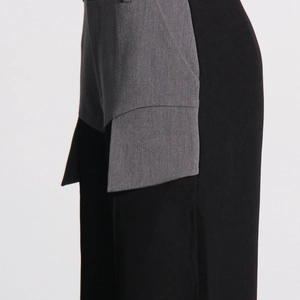 Close-up of contrast patchwork design and side pocket on black and grey trousers