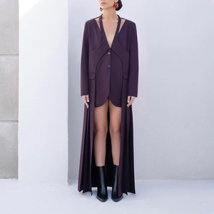 Detail view of deep purple V-neck coat with creative cutouts and layered draped hemline