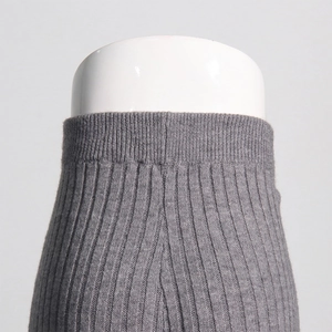 Detail shot of grey ribbed knit trousers with vertical stripes and precise stitching