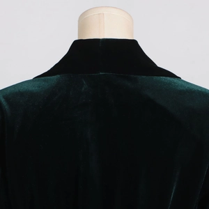 Detail view of dark green velvet blazer collar and back texture on a mannequin