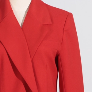 Détail du blazer rouge avec col à revers et texture de tissu sergé haut de gamme