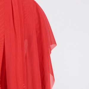 Detailed macro view of the layered red mesh fabric texture with elegant pleated folds