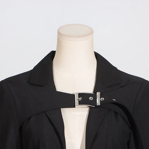 Detail of silver square buckle and metal eyelets on a black twill trench coat