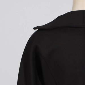 Detailed view of wide lapel and shoulder seam on premium black tailored jacket