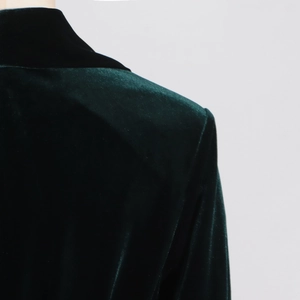 Close-up of premium dark green velvet blazer fabric with elegant glossy texture details