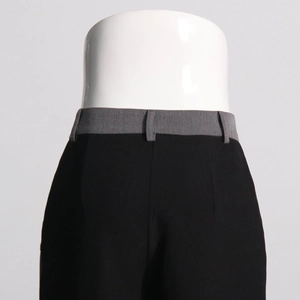 Detail of high-waist straight trousers featuring contrast grey waistband and black fabric