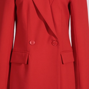 Détail d'une veste de costume rouge à double boutonnage avec poches à rabat