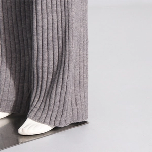 Detail shot of grey ribbed knit texture and drape of wide-leg loungewear trousers