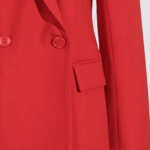 Détail du blazer rouge croisé montrant la texture du sergé et les boutons assortis