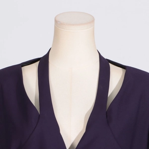 Detail of dark purple trench coat featuring a unique halter neckline and woven texture