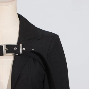 Detail of black trench coat featuring industrial metal buckle and stylish strap design