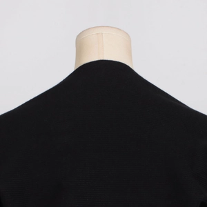 Detail showing the back neckline and shoulder craftsmanship of a black knit top