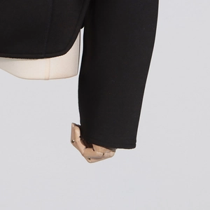 Close-up of black tailored jacket cuff showing refined stitching and premium fabric texture