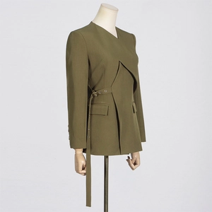 Detail of olive green blazer with asymmetric layered cut and metal eyelet side belt