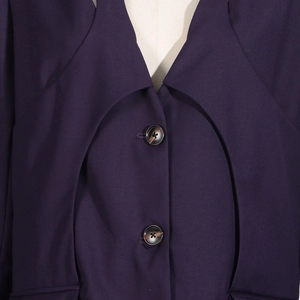 Detailed view of dark purple blazer with curved layering and tortoiseshell buttons