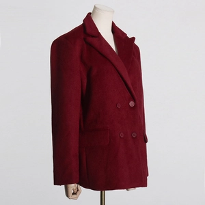 Détail de manteau en laine bordeaux montrant les boutons à double boutonnage et le revers