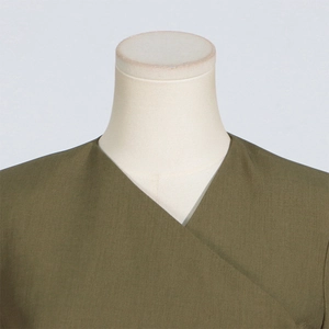 Detail of olive green V-neck top showing premium woven texture on a mannequin