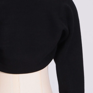 Macro shot of black ribbed knit cropped bolero shrug showing fine fabric texture