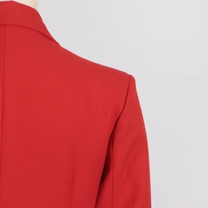 Détail de l'épaule ajustée et des coutures sur un blazer long rouge vif