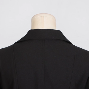 Close-up of the collar and shoulder tailoring on a sleek black trench coat