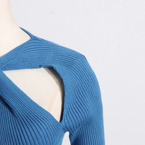 Detail of blue ribbed knit sweater featuring elegant shoulder cut-out and cross design