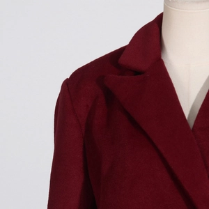 Gros plan détaillé du manteau en laine bordeaux montrant le revers et la texture d'épaule