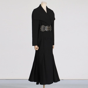 Detail of elegant black long coat featuring a structured lapel and gray metal buckle waist belt