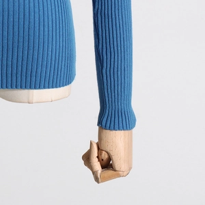 Detail of blue ribbed knit sweater showing refined texture and sleeve cuffs on a mannequin