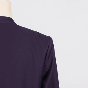 Detail view of the back shoulder seam and smooth fabric texture on this dark purple blazer