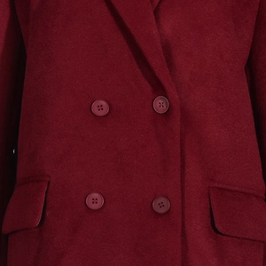Détail d'un manteau en laine bordeaux avec fermeture à double boutonnage et poches à rabat