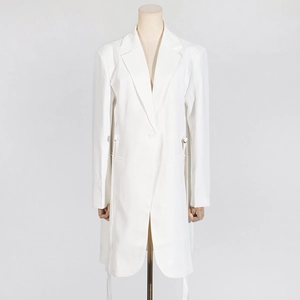 Détail de la robe blazer blanche avec lanières à la taille et boucles métalliques rondes