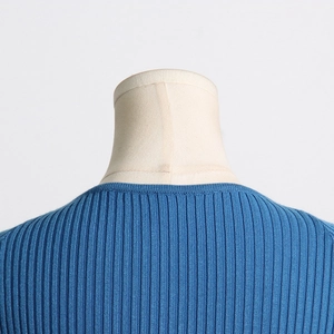 Detailed close-up of the ribbed crew neck and fine knit texture on a blue sweater