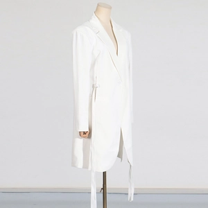 Détail d'une robe blazer blanche à manches longues avec lien de serrage latéral élégant