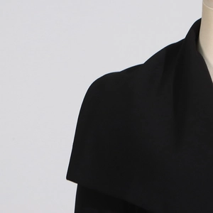 Detail of elegant black trench coat featuring a wide notched lapel on a mannequin