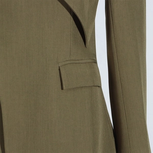 Detailed macro shot of olive green blazer pocket with premium twill fabric texture