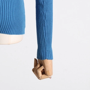 Detail of blue ribbed knit sweater showing textured long sleeves and elastic fabric