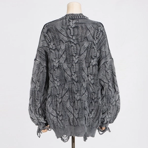 Macro view of gray cable knit sweater featuring vintage distressed ripped hem details