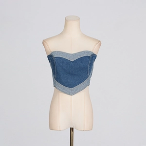 Dettaglio del corsetto in denim con inserti a cuore e pannelli blu bicolore