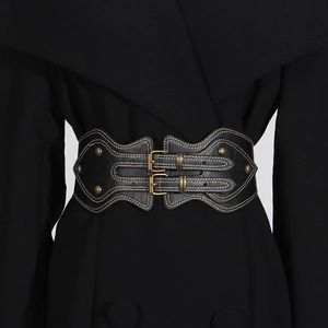 Detail of vintage black wide waist belt featuring brass buckles and contrast yellow stitching