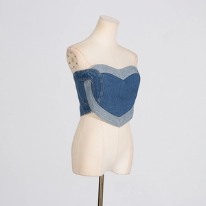 Dettaglio del corsetto in denim con patchwork a forma di cuore e cuciture a contrasto