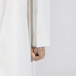 Gros plan des poignets et coutures latérales d'une robe blazer blanche à manches longues
