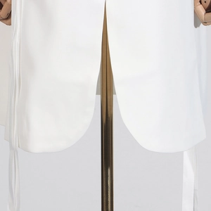 Détail de la robe blazer blanche montrant la fente de l'ourlet et le lien à la taille