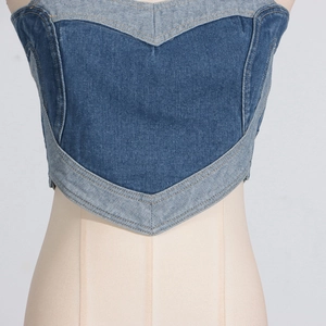 Dettaglio del top a bustino in denim blu con patchwork a cuore e cuciture a contrasto