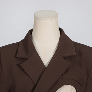 Détail du blazer avec découpes en forme de croissant irrégulier et revers classique