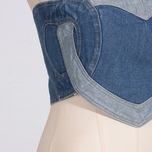 Dettaglio del top a fascia in denim blu con patchwork a forma di cuore e impunture